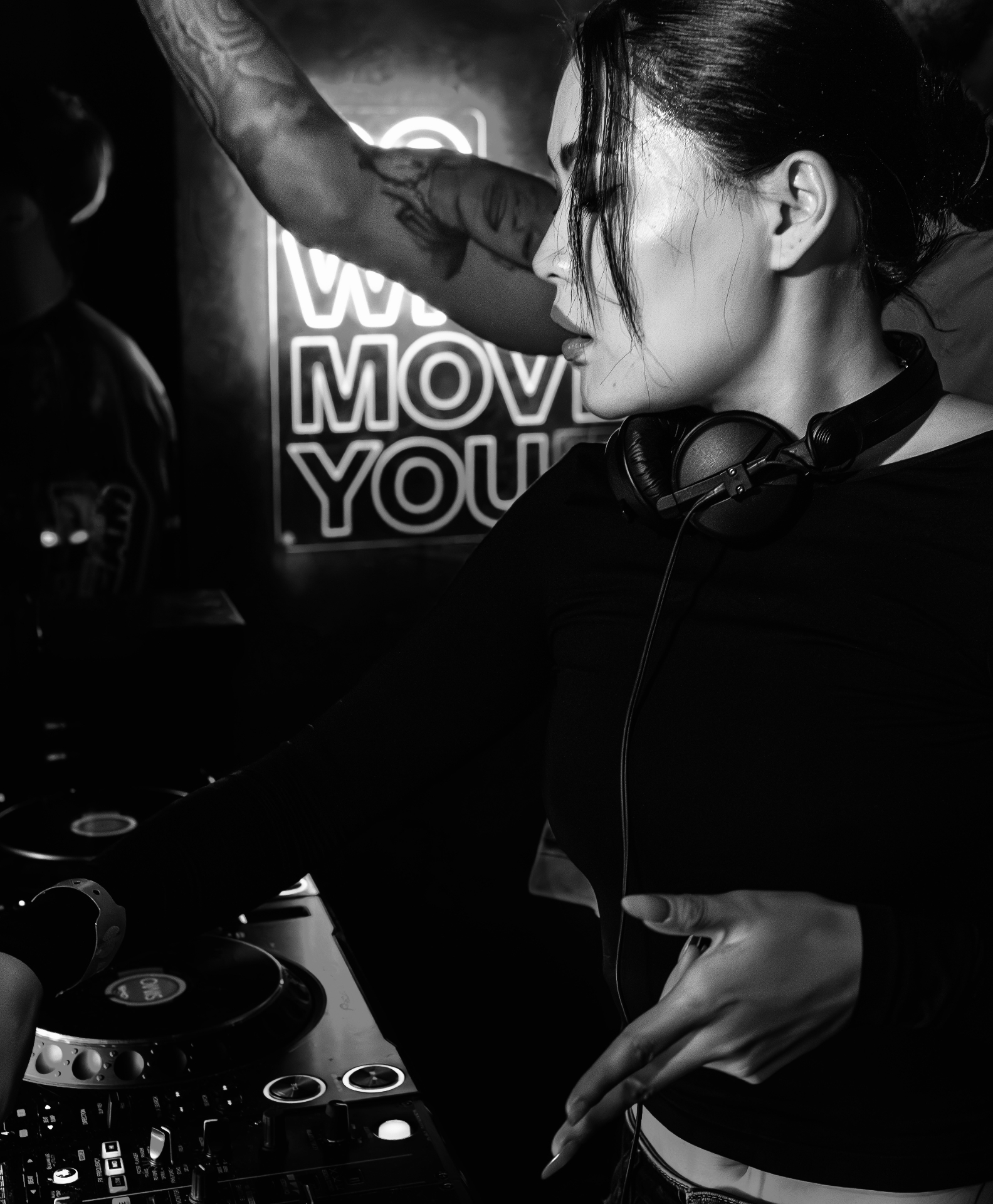 DJ Tianyu mixing under neon sign